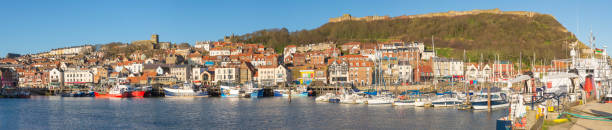 istock Harbor seafront town with castle on hill 1311932963