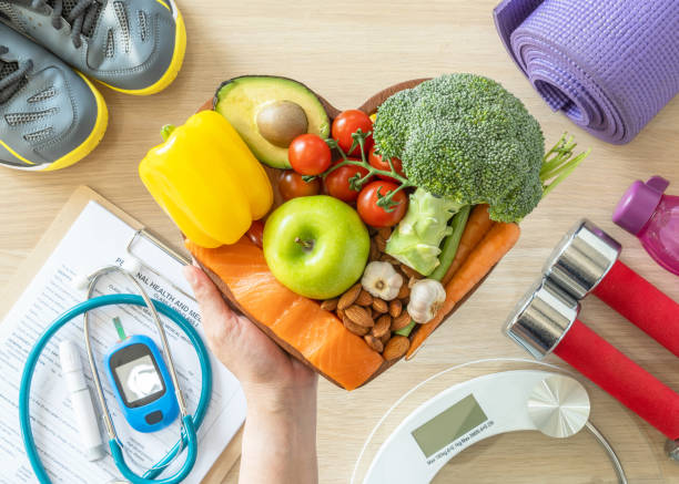 gesunder lebensstil auf ketogene ernährung, essen saubere keto essen gute gesundheit diät in herzschale mit aeroben körperübung, fitness-studio-trainingskurs, gewichtsskala und sportschuhe im fitnesscenter - cholesterin stock-fotos und bilder