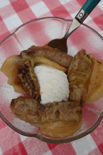 Bananas and pears cooked in butter and flambéed with rum served with a scoop of ice cream