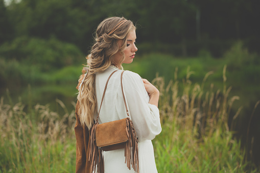 Beautiful woman with suede handbag outdoor