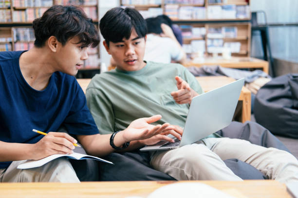 istock Young students campus helps friend catching up and learning. 1311943730