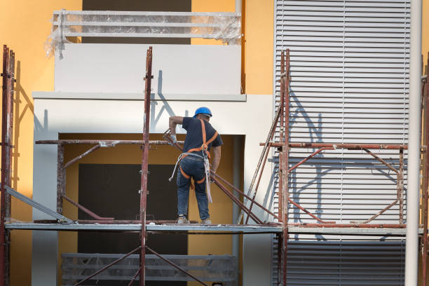 istock Worker with Blue Hardhat at Work on a Scaffold in a Building Site for the Construction of a Building 1311946709