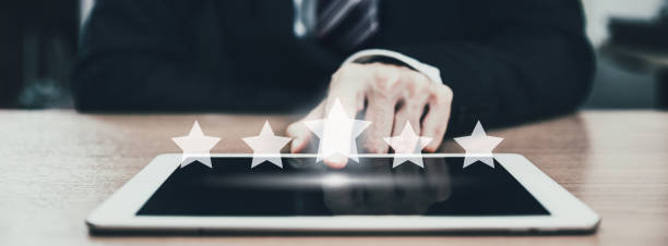 istock Business man using tablet with graphic of customer service star rate in mobile application 1311947699