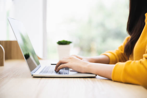 istock Woman using computer laptop on wood desk. She working at home 1311949581