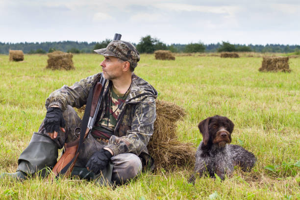 istock hunter with his dog resting on the hayfield 1311949726
