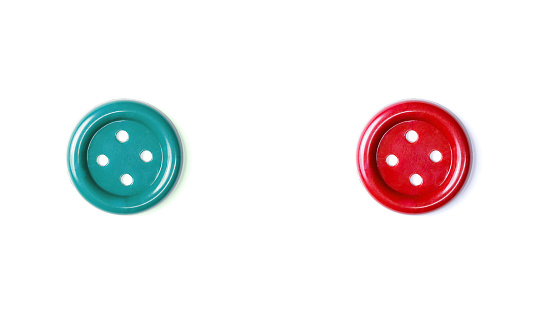 Red and green buttons on a white background close-up. Two beautiful isolate buttons for cutting out. Copy space. Top view. Flat lay. Button for crafts.