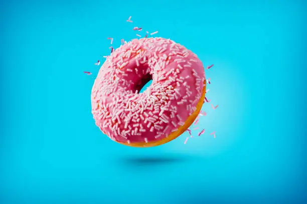 Photo of Freshly baked donuts isolated on colourful background