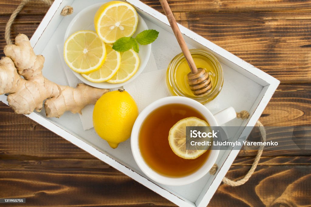 Top view of green tea with lemon, honey and ginger in the white tray on the wooden table Top view of green tea with lemon, honey and ginger in the white tray on the wooden table. Close-up. Breakfast Stock Photo