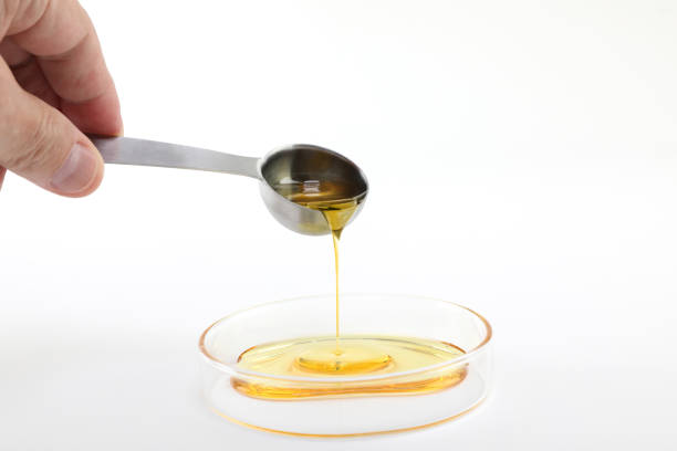 istock Pouring high quality CBD oil Distillate into a Petri dish 1311956418