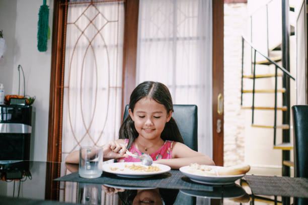 istock Beautiful Little Girl Eating Alone 1311956573