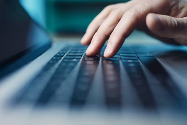 istock Fingers of person during using laptop at night 1311956762