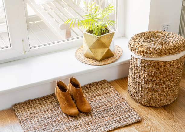 plancher de bois franc avec paillasson de jute, chaussures et pot de fleur et panier à linge d’herbe de mer par fenêtre. objets matériels naturels dans le concept de maison. intérieur de la maison. - rug carpet decor woven photos et images de collection