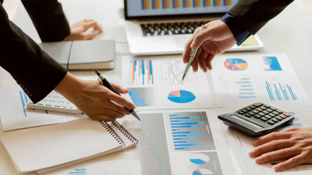 istock A businessman sits at the graph analysis desk. On graphics and charts with office calculators 1311961605