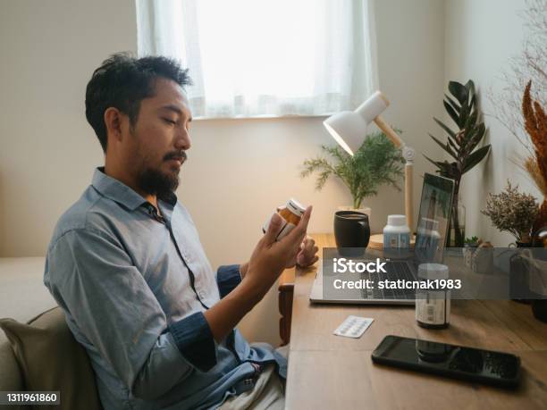 Asian Man A Video Telemedicine Call With A Doctor Stock Photo - Download Image Now - Prescription Medicine, Taking Medicine, Men