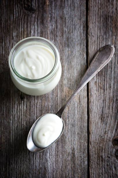 istock Yoghurt pot, wooden table background 1311967186