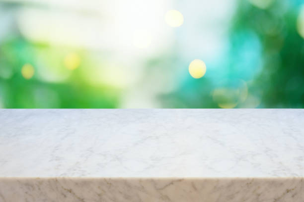 istock Empty marble table over green blurred background.  Summer mock up for design and product display. Selective focus on marble tabletop. 1311968030