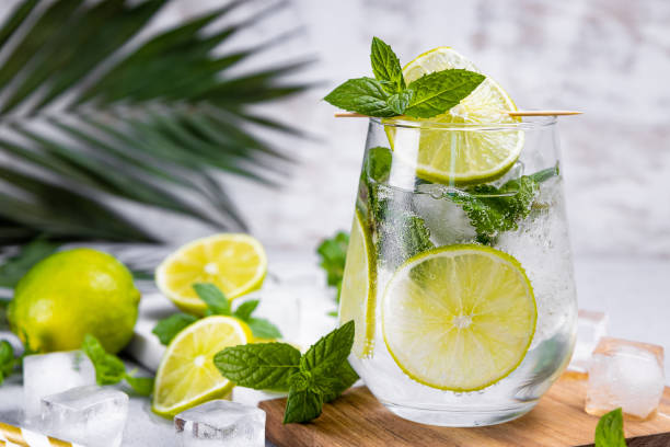 istock Refreshing mojito with lime, mint and ice in a glass on a summer background, free space for text. Cold summer cocktail 1311969670