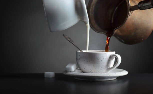 istock Cream and coffee is poured into a cup. 1311969821