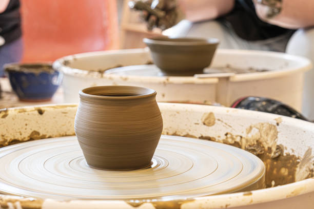 olla de barro recién hecha en la rueda de un alfarero. clase magistral en el taller de cerámica - making craft craftsperson circle fotografías e imágenes de stock