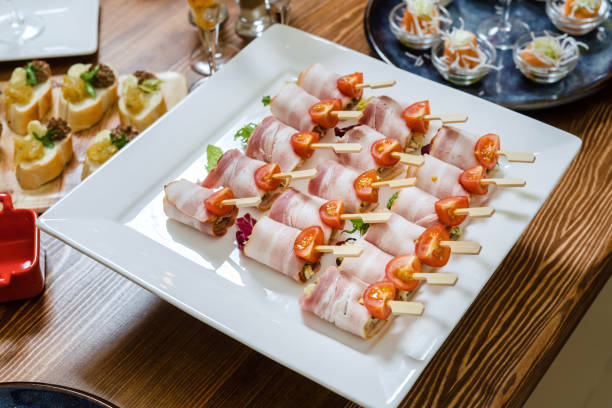 istock Bacon rolls stuffed with cheese and salad, a table with catering. 1311973969