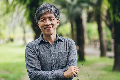 Portrait of a middle aged Chinese ethnicity man in a park