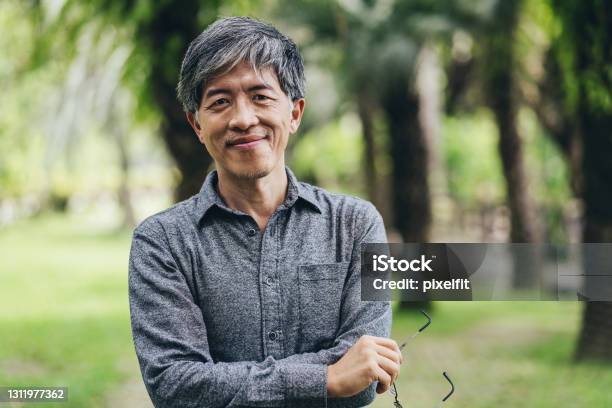 Mid Age Chinese Ethnicity Man In The Park Stock Photo - Download Image Now - Men, Asian and Indian Ethnicities, East Asian Culture