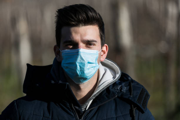 istock Young Man Putting On Protective Mask Outdoors in Nature 1311985773