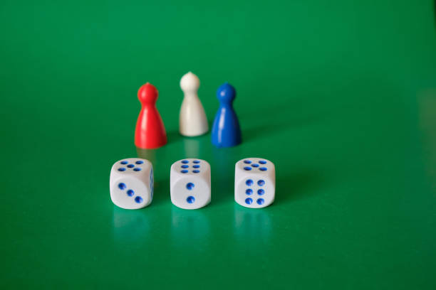 istock Colored game figures chips for board games. Collection of dice cubes on green table. 1311987442