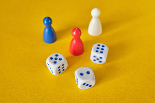 istock Colored game figures chips for board games. Collection of dice cubes on yellow table. 1311987443