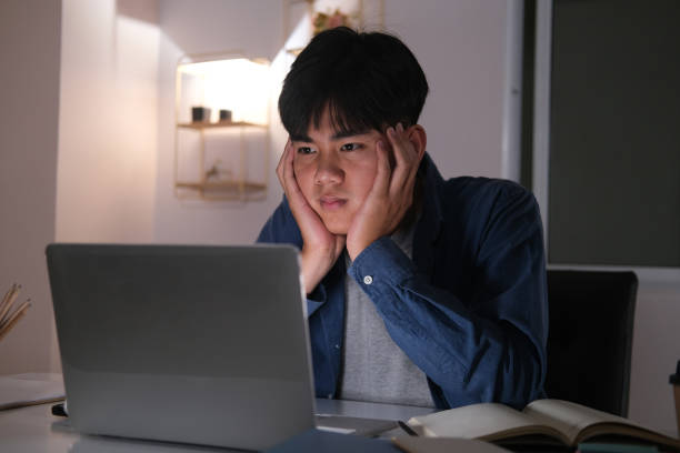 istock Sleepy exhausted collage young man working overtime. 1311988177