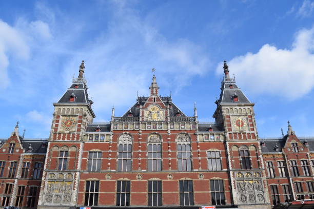 istock Amsterdam Central train station, old beautiful architecture and vibrant colored buildings. 1311992604