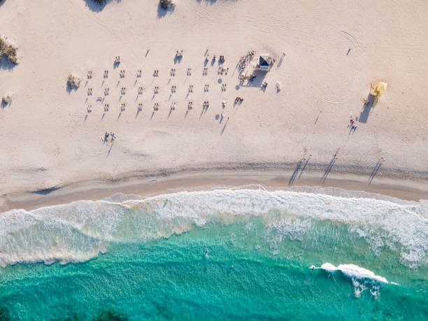 istock White sand beach with people sunbathing and surfing aerial top view 1311996604