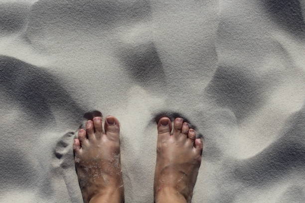 istock Feet on white sand with sunshine snax 1311997489