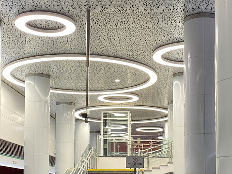 Shiny beautiful shining expensive white high-tech futuristic ceiling with round neon lamps.