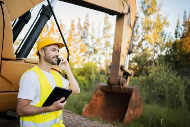 istock Worker at a construction site buying something using a smart phone and a tablet. 1312005865