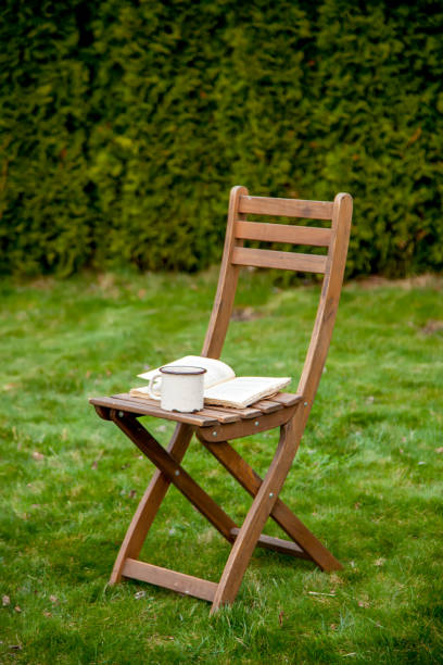 istock Old book with cup of tea on a table on green grass in spring 1312006998