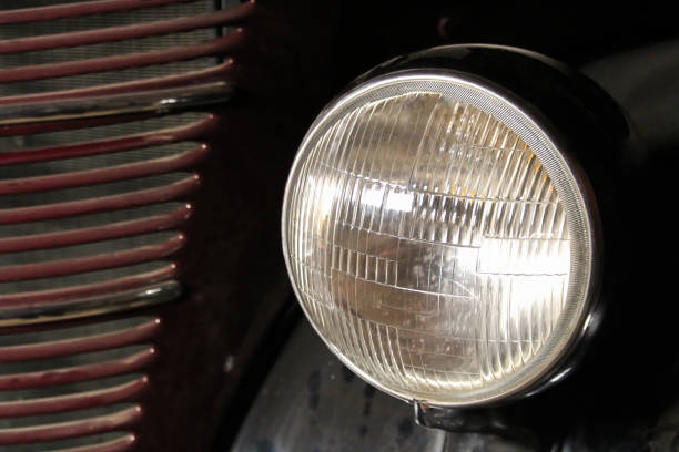 Central headlight detail on a goldenrod classic car. Closeup