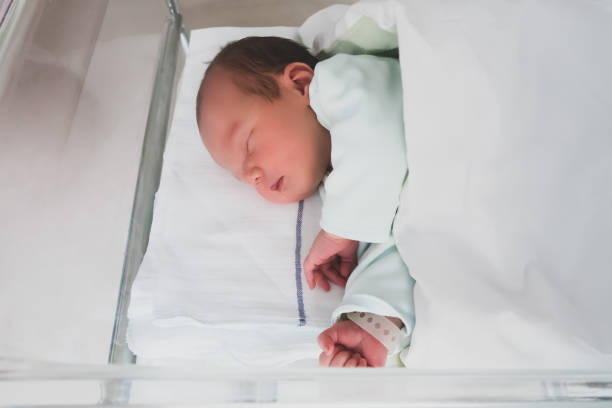 istock Newborn baby is sleeping in small transparent portable plastic bed. 1312011646
