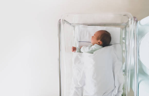 istock Newborn baby is sleeping in small transparent portable plastic bed. 1312011655