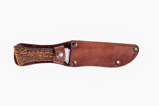 A hunting knife with a leather scabbard and a deer horn handle. Accessories for hunters hunting deer. Isolated background.