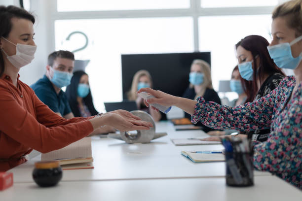 istock new normal businesspeople on meeting using antibacterial hand sanitizer 1312016175