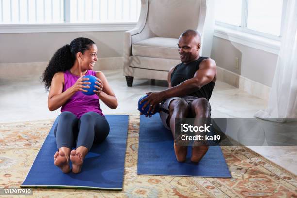 Couple At Home Exercising Together With Medicine Balls Stock Photo - Download Image Now