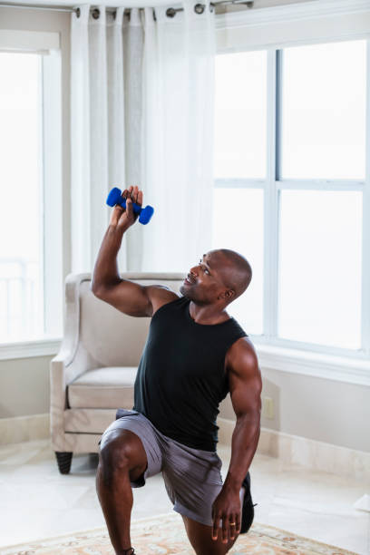 istock African-American man exercising at home, doing lunges 1312018015