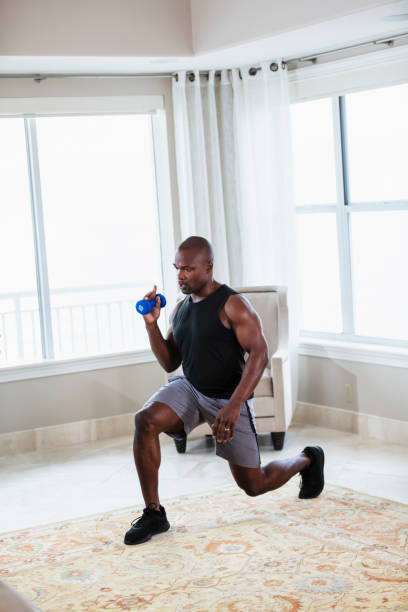 istock African-American man exercising at home, doing lunges 1312018555