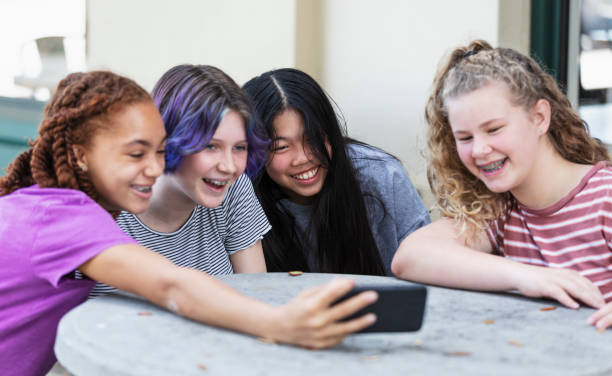 istock Four tween girls watching video on mobile phone 1312018648