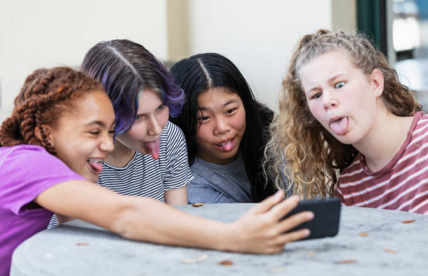 istock Four tween girls using smart phone for video call 1312018656