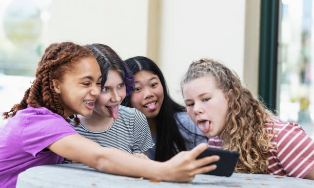 istock Four tween girls using smart phone for video call 1312018657