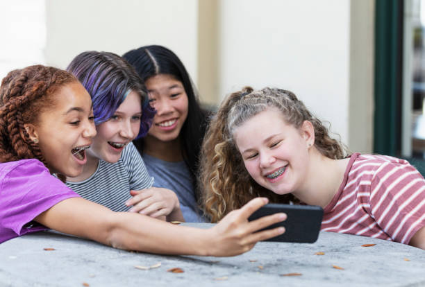istock Four tween girls watching video on mobile phone 1312018658