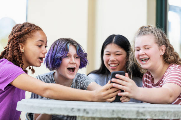 istock Four tween girls looking at smart phone, laughing 1312018675
