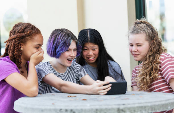 istock Four tween girls looking at smart phone, shocked faces 1312018696